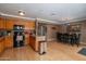 Eat-in kitchen featuring wood cabinets, black appliances and a breakfast bar with pendant lighting at 2875 W Highland St # 1152, Chandler, AZ 85224