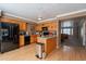 Well-equipped kitchen features wood cabinets, black appliances, and a serving bar, seamlessly flowing into the living area at 2875 W Highland St # 1152, Chandler, AZ 85224