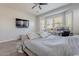 Bright bedroom featuring large window, ceiling fan and ensuite entertainment center with TV at 3028 W T Ryan Ln, Phoenix, AZ 85041