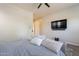 This primary bedroom has a ceiling fan and a large television at 3028 W T Ryan Ln, Phoenix, AZ 85041