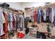 This walk-in closet has clothing hung on racks and boxes and containers on the floor at 3028 W T Ryan Ln, Phoenix, AZ 85041