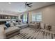 Open living area with ceiling fan, large sectional sofa, and views of the kitchen and backyard at 3028 W T Ryan Ln, Phoenix, AZ 85041