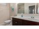 Bright bathroom featuring a framed mirror, vanity with storage, and a glass-enclosed shower/tub combination at 30993 W Indianola Ave, Buckeye, AZ 85396
