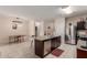 Open concept kitchen with stainless steel appliances, granite counters, island seating, and adjacent dining space at 30993 W Indianola Ave, Buckeye, AZ 85396