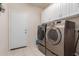 Well-equipped laundry room features modern washer and dryer, and built in cabinets at 30993 W Indianola Ave, Buckeye, AZ 85396