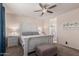 Spacious main bedroom with stylish white furniture, ceiling fan, and access to the bathroom at 30993 W Indianola Ave, Buckeye, AZ 85396