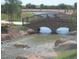 Arched walking bridge with stone supports over a stream in Layton Lakes community at 3381 E Azalea Dr, Chandler, AZ 85286
