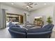 Bright living room featuring comfortable blue sofas, ceiling fan, and sliding glass doors leading to a covered patio at 3381 E Azalea Dr, Chandler, AZ 85286