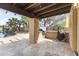 Covered outdoor kitchen area with grill, stone countertops, and a view of the pool and water feature at 3381 E Azalea Dr, Chandler, AZ 85286
