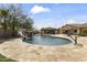 A backyard oasis featuring a swimming pool, grotto water slide, and a large patio area at 3381 E Azalea Dr, Chandler, AZ 85286