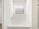 Clean bathtub with chrome fixtures, side window, and neutral walls at 37458 W San Clemente St, Maricopa, AZ 85138