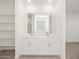 Bathroom featuring double sink vanity, large mirror, and white cabinets at 37458 W San Clemente St, Maricopa, AZ 85138