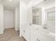 Bathroom features a large mirror, double sink vanity, tile floors, and open shelves at 37458 W San Clemente St, Maricopa, AZ 85138