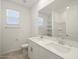Bright bathroom featuring double sinks, white cabinets, a large mirror, and ample natural light at 37458 W San Clemente St, Maricopa, AZ 85138