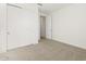 A bright bedroom with large closet doors, fresh paint and plush neutral carpeting at 37458 W San Clemente St, Maricopa, AZ 85138
