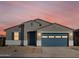 Charming single-story home featuring a blue garage door, shuttered window and neutral stucco at 37458 W San Clemente St, Maricopa, AZ 85138