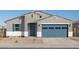Charming single-story home featuring a blue garage door, shuttered window and neutral stucco at 37458 W San Clemente St, Maricopa, AZ 85138