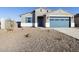 Charming single-story home featuring a blue garage door, shuttered window and neutral stucco at 37458 W San Clemente St, Maricopa, AZ 85138