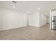 Bright, open-concept living space with neutral tile flooring and stainless-steel appliances at 37458 W San Clemente St, Maricopa, AZ 85138