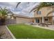Large backyard with artificial turf, covered patio, and lush desert landscape at 3795 W Mercury Way, Chandler, AZ 85226