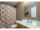 Cozy bathroom featuring a vanity with sink, toilet, and shower with patterned curtain at 3795 W Mercury Way, Chandler, AZ 85226