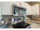 Close up of white cabinets and tiled backsplash in kitchen with stainless steel appliances at 3795 W Mercury Way, Chandler, AZ 85226