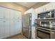 Kitchen with white cabinets, stainless steel appliances, tiled backsplash, and tile flooring at 3795 W Mercury Way, Chandler, AZ 85226