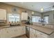 Open kitchen featuring white cabinets, tile backsplash, and a large island/breakfast bar at 3795 W Mercury Way, Chandler, AZ 85226