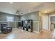 Open concept living space with laminate flooring, ceiling fan, and an entertainment center is filled with light at 3795 W Mercury Way, Chandler, AZ 85226