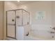 Bright bathroom featuring a glass-enclosed shower and separate soaking tub, creating a spa-like retreat at 40707 W Pryor Ln, Maricopa, AZ 85138