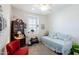 Well-lit bedroom with a daybed, red chair, and a cabinet at 40707 W Pryor Ln, Maricopa, AZ 85138