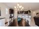 Bright dining area with chandelier, dark wood table, and views into kitchen at 40707 W Pryor Ln, Maricopa, AZ 85138