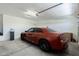 Spacious garage with an orange sedan and water softener system, offering ample storage and convenience at 40707 W Pryor Ln, Maricopa, AZ 85138