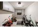 Organized garage with overhead storage cabinets and space for bikes and equipment at 40707 W Pryor Ln, Maricopa, AZ 85138