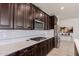 Kitchen showcasing stainless steel appliances, sleek dark cabinetry, and white countertops at 40707 W Pryor Ln, Maricopa, AZ 85138