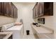 Functional laundry room with cabinets, counter space, and a washer-dryer at 40707 W Pryor Ln, Maricopa, AZ 85138