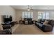 Comfortable living room with plush leather sofas, a ceiling fan, and neutral-toned decor at 40707 W Pryor Ln, Maricopa, AZ 85138