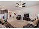 Spacious living room featuring neutral tile flooring, a comfortable leather sofa, and a media center at 40707 W Pryor Ln, Maricopa, AZ 85138