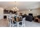 Open-concept living space featuring a modern kitchen, dining area, and comfortable seating with tile flooring at 40707 W Pryor Ln, Maricopa, AZ 85138