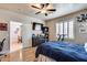 Comfortable bedroom featuring a ceiling fan, a television, wood-look floors and shuttered windows at 4539 W Beautiful Ln, Laveen, AZ 85339