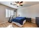 Comfortable bedroom with a ceiling fan, a treadmill and shuttered windows with wood-look floors at 4539 W Beautiful Ln, Laveen, AZ 85339