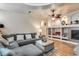 Cozy living room with a grey sectional, built-in shelves, fireplace, and a ceiling fan at 4539 W Beautiful Ln, Laveen, AZ 85339