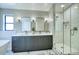 Elegant bathroom featuring double vanity, sleek mirrors, and a glass-enclosed shower with modern fixtures at 4602 N 74Th Pl, Scottsdale, AZ 85251