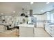 Bright, open kitchen with white cabinets, stainless steel appliances, island with bar seating, and pendant lighting at 4602 N 74Th Pl, Scottsdale, AZ 85251