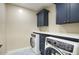 Laundry room with blue cabinets, white counters, and modern front load washer and dryer at 4602 N 74Th Pl, Scottsdale, AZ 85251