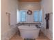 Bright bathroom featuring a soaking tub with shuttered windows and tile accents at 4617 E Elmwood Cir, Mesa, AZ 85205