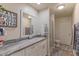 Well-lit bathroom with granite countertop, modern fixtures, and glass-enclosed shower at 4617 E Elmwood Cir, Mesa, AZ 85205