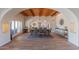An airy dining room boasts wood-beamed ceilings, modern light fixtures, and large windows for natural light at 4617 E Elmwood Cir, Mesa, AZ 85205