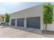Attached four-car garage with dark gray doors and manicured landscaping around perimeter at 4617 E Elmwood Cir, Mesa, AZ 85205