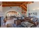 A spacious living room with wooden ceilings, an area for dining, and a full bar with marble countertops and wine storage at 4617 E Elmwood Cir, Mesa, AZ 85205